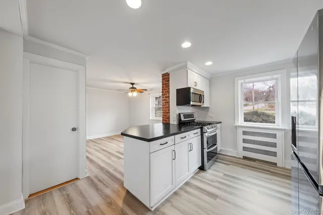 a kitchen with stainless steel appliances granite countertop a stove and a white cabinets