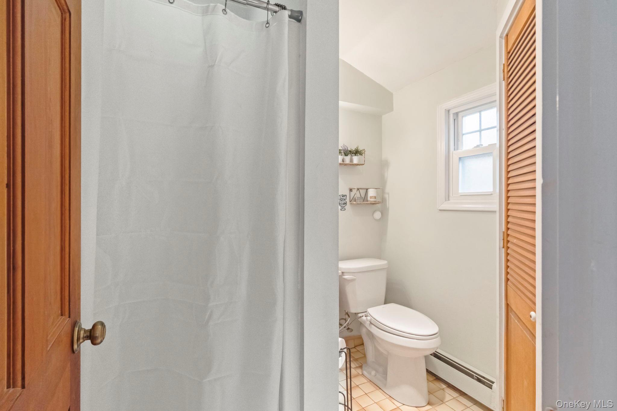 18 Lakeview Road Carmel, NY 10512 - Photo 37 of 44 a white toilet sitting next to a bathroom sink and vanity
