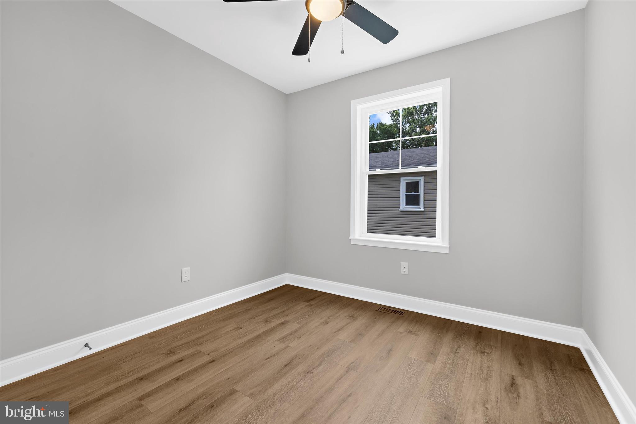 211 Greenland Beach Road Greenland Beach, MD 21226 - Photo 14 of 48 an empty room with a window and wooden floor