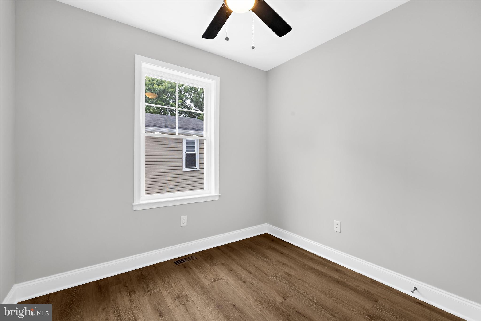 211 Greenland Beach Road Greenland Beach, MD 21226 - Photo 17 of 48 an empty room with a window and wooden floor