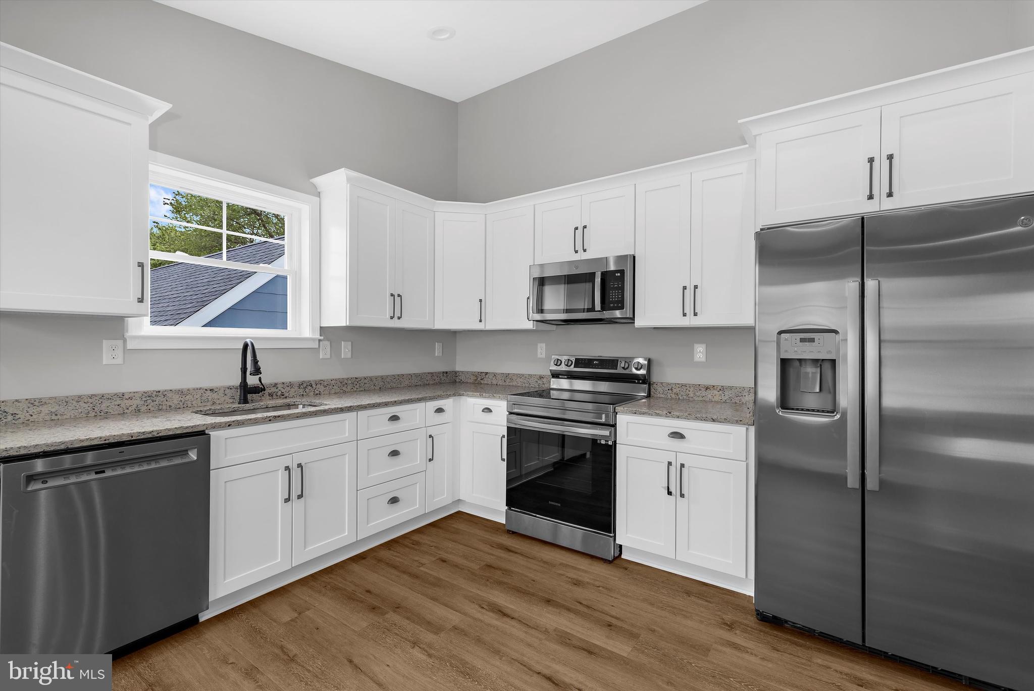 211 Greenland Beach Road Greenland Beach, MD 21226 - Photo 5 of 48 a kitchen with stainless steel appliances granite countertop a stove a sink dishwasher a refrigerator and a microwave oven with wooden floor