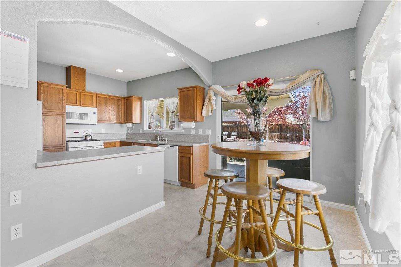 9625 Marble Creek Court Reno, NV 89506 - Photo 11 of 40 a kitchen with stainless steel appliances kitchen island granite countertop a table and chairs in it