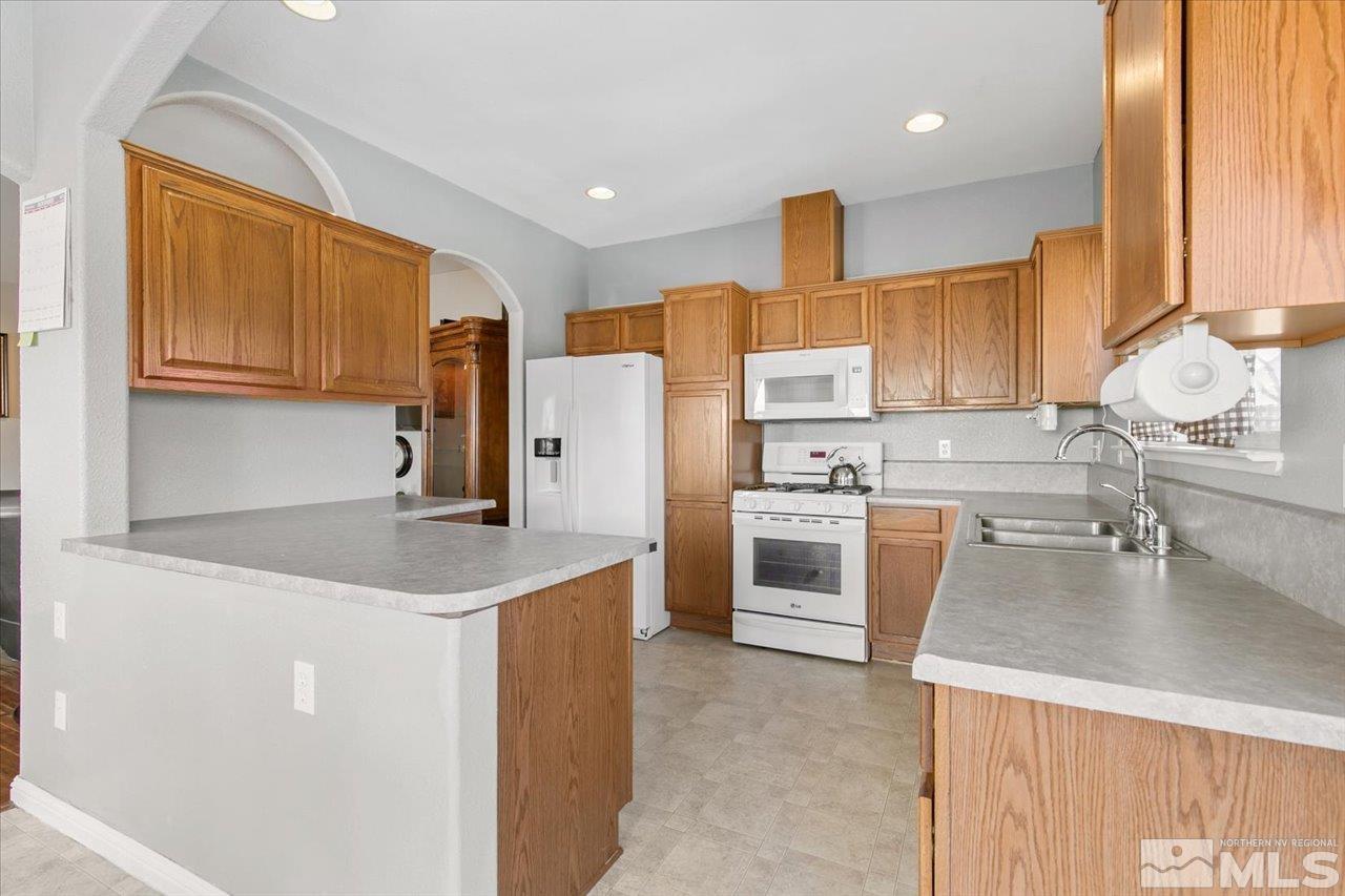 9625 Marble Creek Court Reno, NV 89506 - Photo 14 of 40 a kitchen with a sink a stove a refrigerator and cabinets