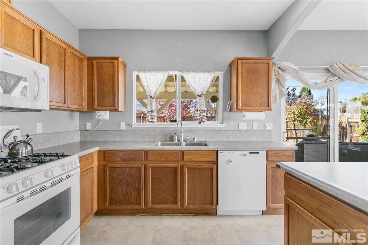 9625 Marble Creek Court Reno, NV 89506 - Photo 15 of 40 a kitchen with stainless steel appliances granite countertop a sink stove and cabinets
