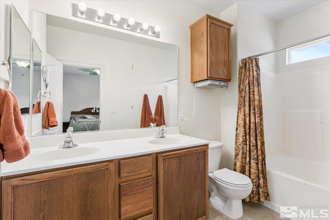 9625 Marble Creek Court Reno, NV 89506 - Photo 22 of 40 a bathroom with a sink a toilet and mirror
