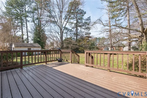 a balcony with wooden floor and trees