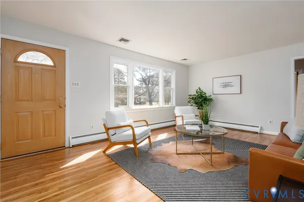 a living room with furniture and wooden floor