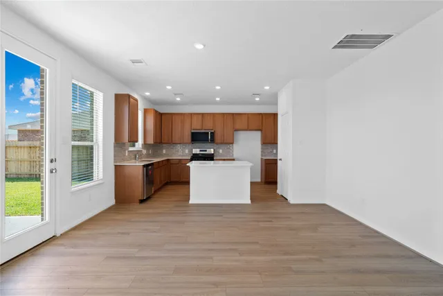a view of kitchen with kitchen island microwave and cabinets
