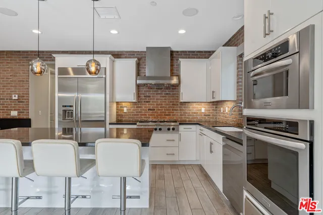 a kitchen with stainless steel appliances granite countertop a stove and a sink