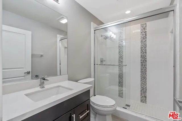 a bathroom with a granite countertop sink toilet and shower