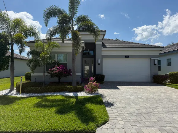 a front view of a house with a yard and a garage