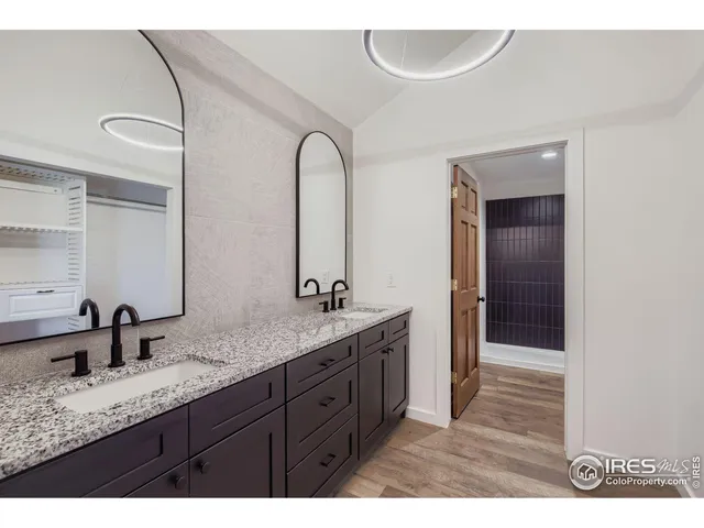 a bathroom with a granite countertop sink a mirror and shower