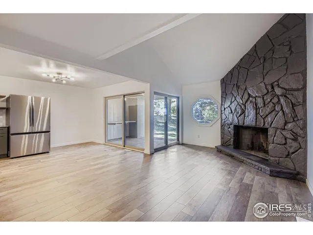 a view of an empty room with a fireplace and a window