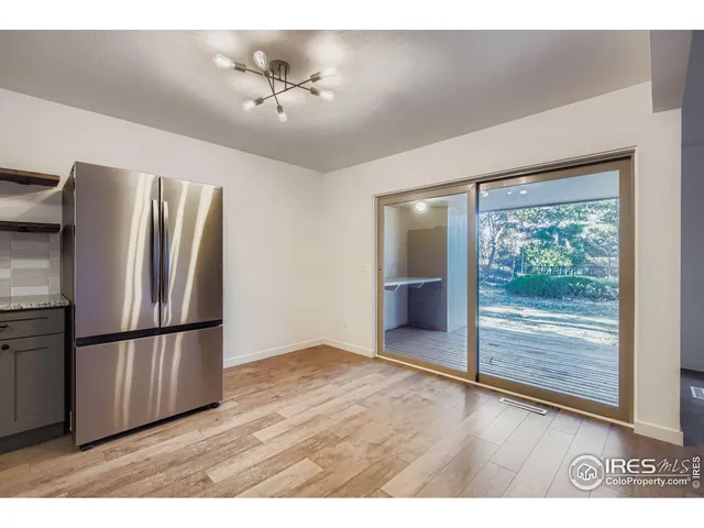 a view of kitchen with furniture refrigerator and wooden floor