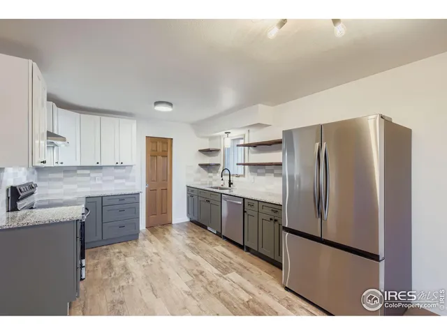 a kitchen with a refrigerator sink and cabinets