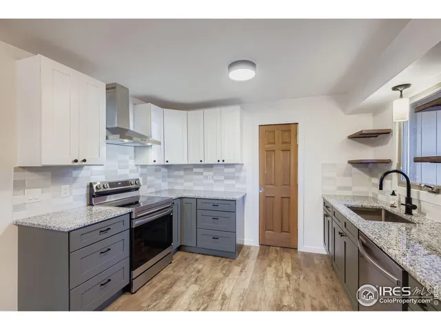 a kitchen with granite countertop a sink stove and cabinets