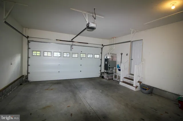 a bedroom with a bed a chair and large mirror in it