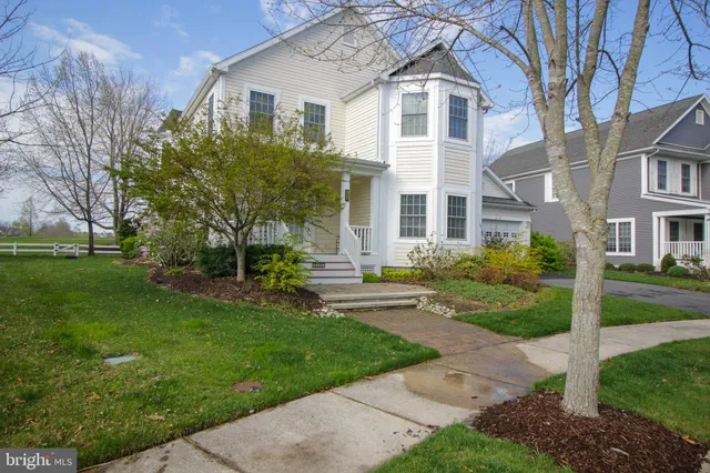 a front view of a house with a yard and trees