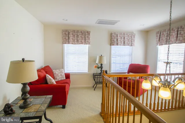 a view of a white house with large windows and flower plants