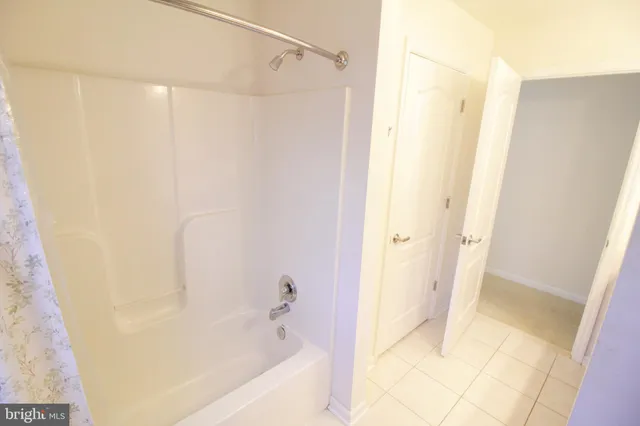 a view of a house with a big yard and large tree