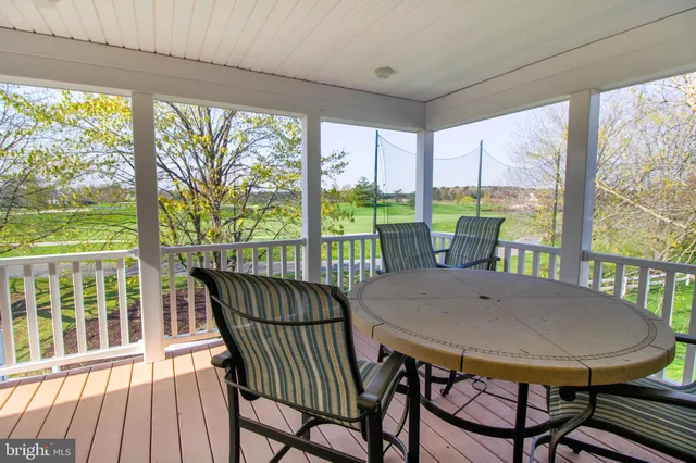 a front view of a house with a garden and lake view