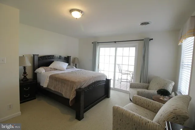 a view of a lake with a yard and large trees