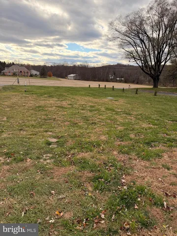 a view of a large pool with lawn chairs and a big yard