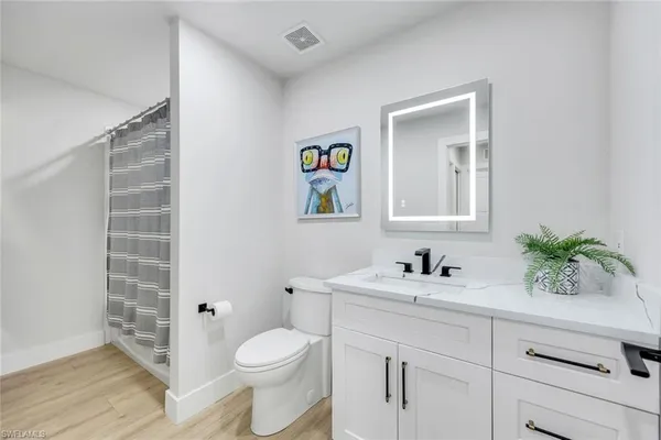 a bathroom with a sink a toilet and shower