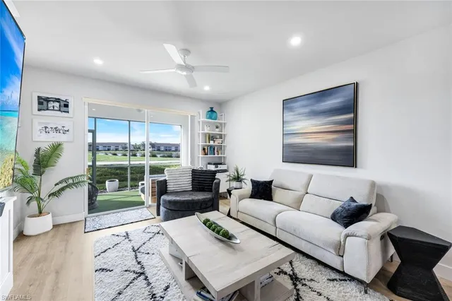 a living room with furniture potted plant and a large window