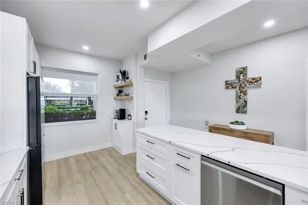 a kitchen that has a lot of cabinets a sink and wooden floor
