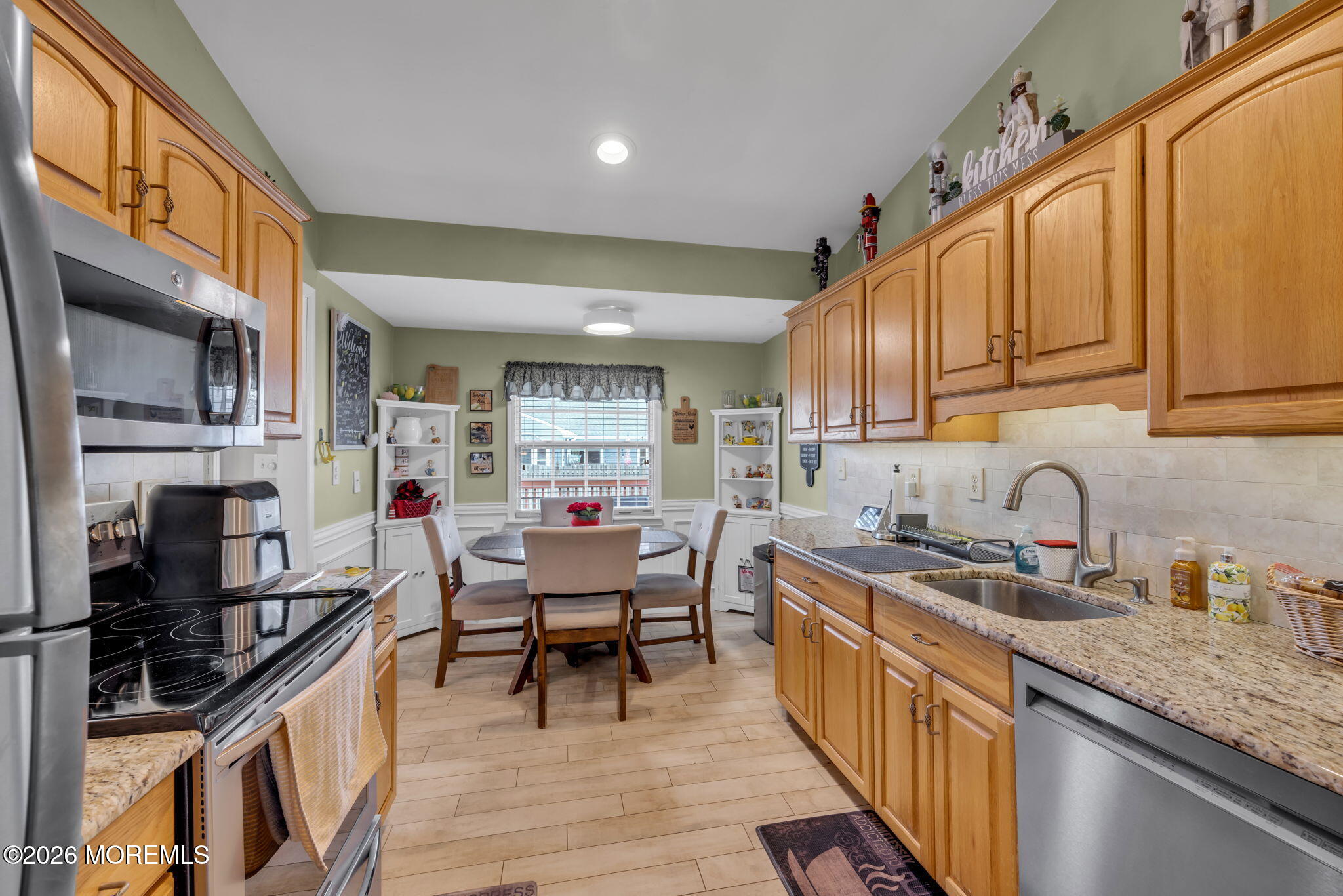 a kitchen with stainless steel appliances granite countertop a stove a sink dishwasher and cabinets with wooden floor
