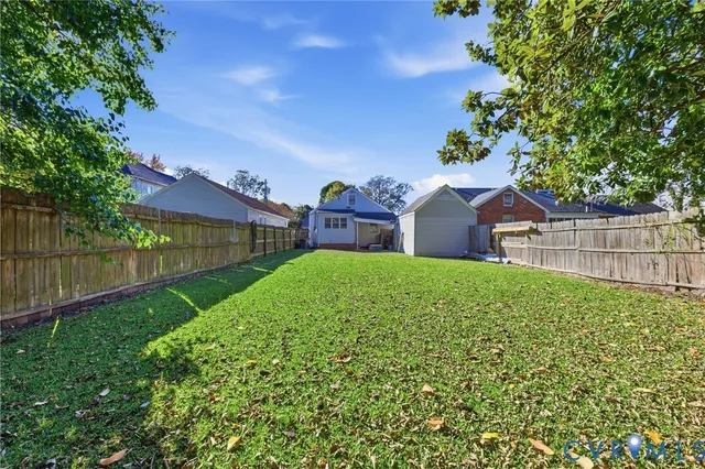 a view of a yard in front of a house with a large tree
