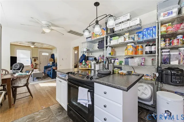 a living room with lots of furniture and a kitchen view