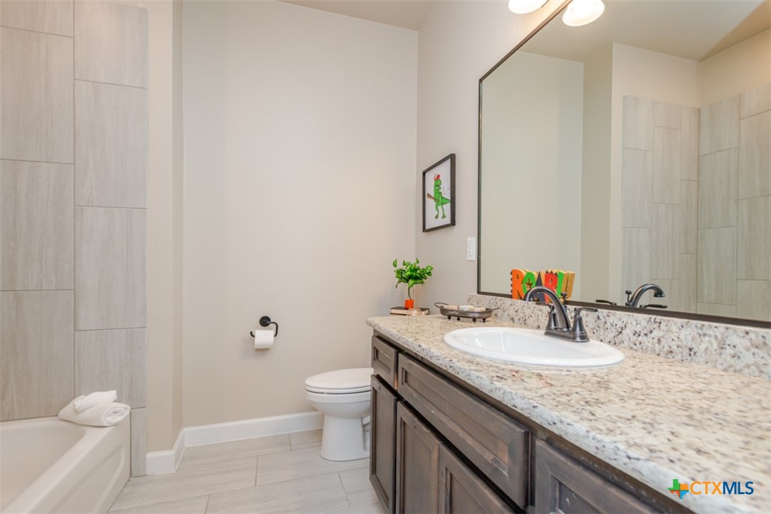 3497 Hooten Bend Kempner, TX 76539 - Photo 11 of 36 a bathroom with a granite countertop sink a toilet and a mirror