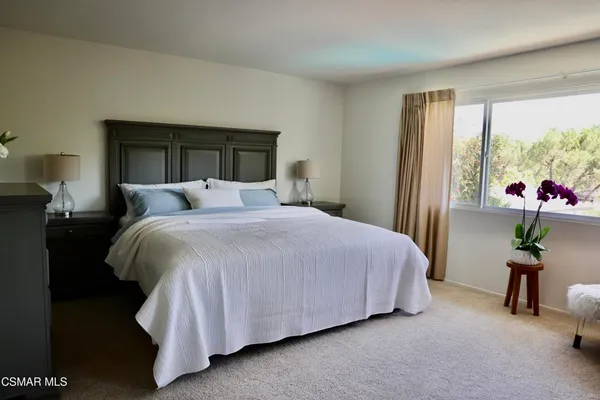 a bed room with a bed and potted plant