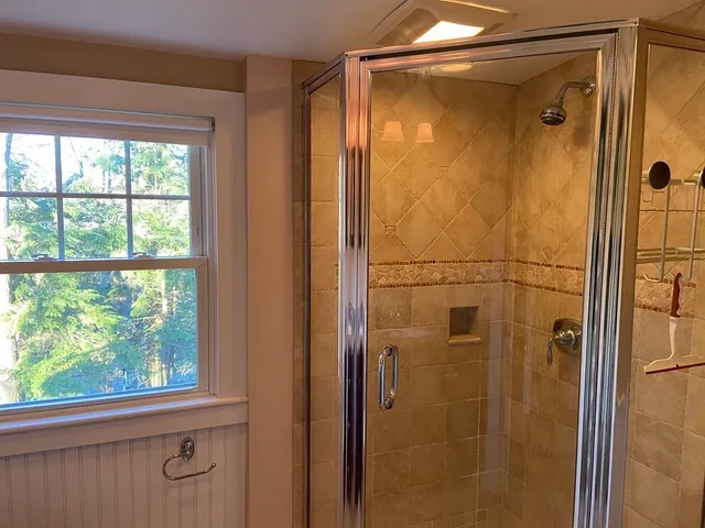 a bathroom with a glass shower door and mirror