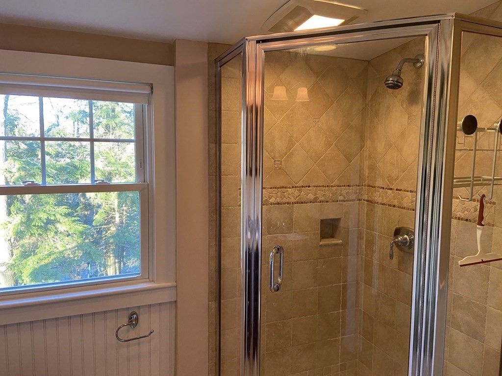 751 Central Avenue Needham, MA 02494 - Photo 16 of 21 a bathroom with a glass shower door and mirror