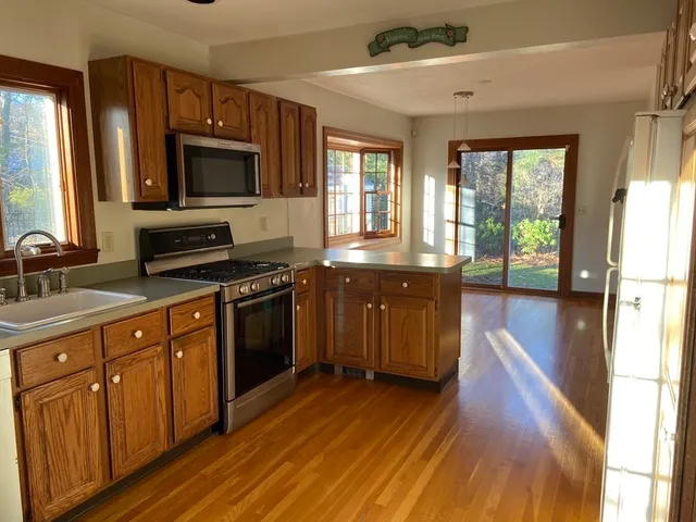 a kitchen with granite countertop a stove top oven sink and cabinets