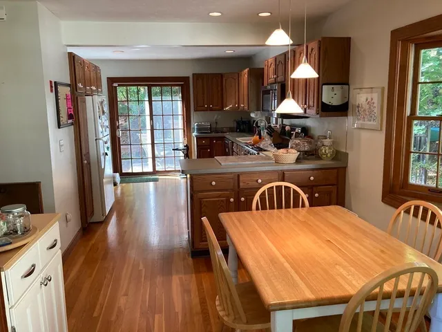 a kitchen with a table chairs stove and wooden floor