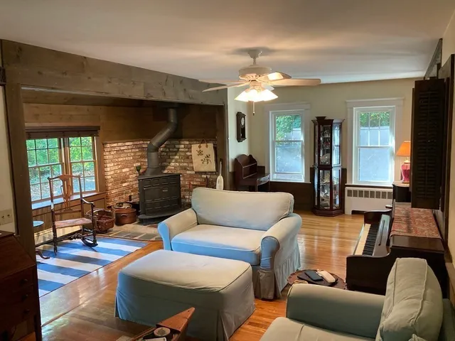 a living room with furniture a large window and a chandelier