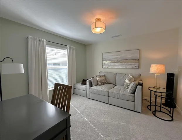 a living room with furniture and a lamp