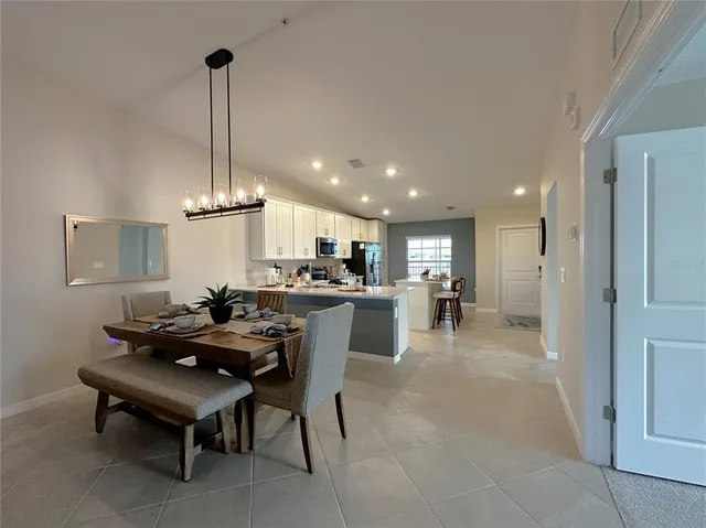 a view of a dining room and livingroom with furniture wooden floor a chandelier