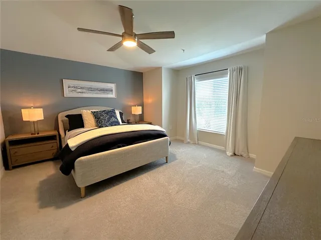 a bedroom with a bed and a ceiling fan
