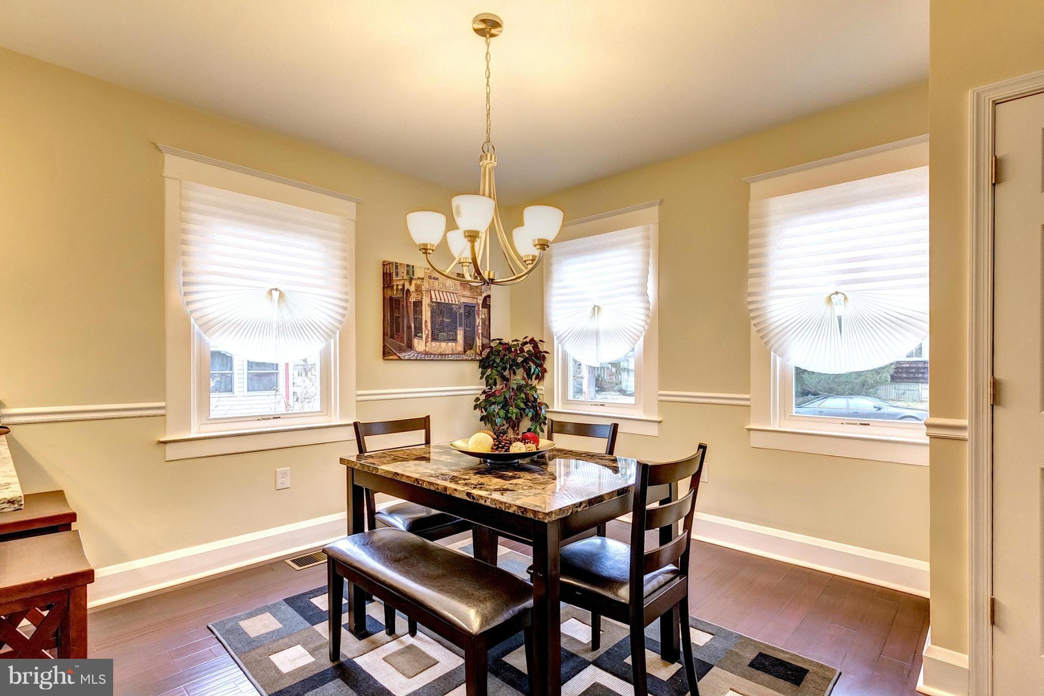 5800 Clearspring Road Baltimore, MD 21212 - Photo 5 of 30 a dining room with wooden floor a chandelier a wooden table and chairs