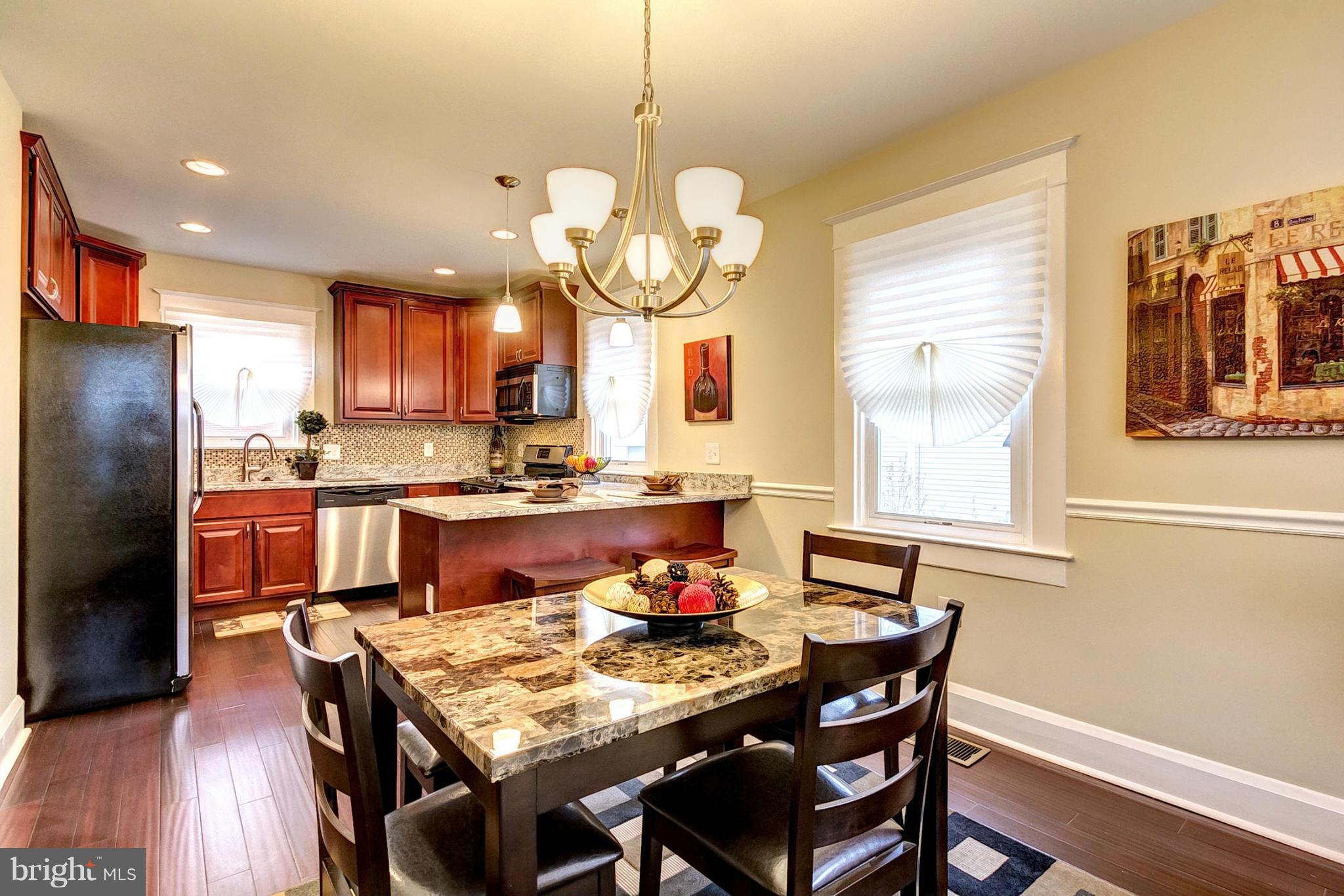 5800 Clearspring Road Baltimore, MD 21212 - Photo 6 of 30 a kitchen with stainless steel appliances granite countertop a dining table chairs and chandelier