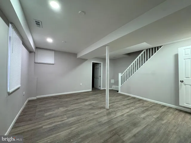 an empty room with wooden floor and entryway