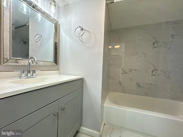 a bathroom with a shower sink vanity and mirror