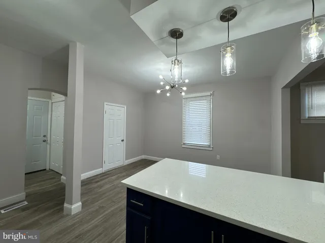 a room with chandelier and wooden floor