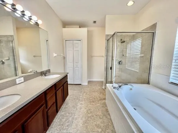 an empty room with wooden floor and fan