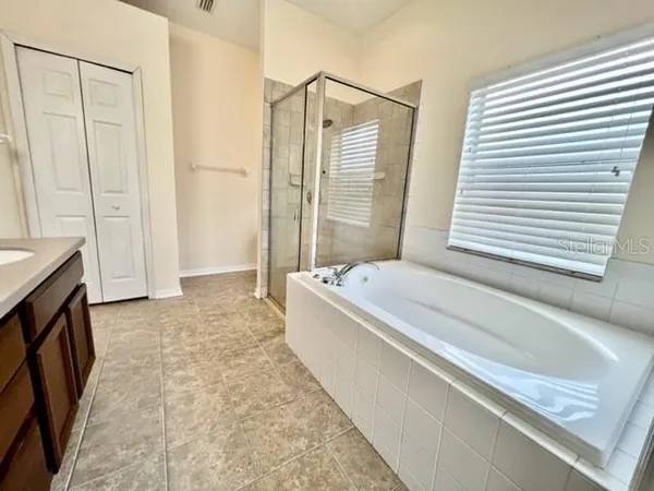 a bathroom with a double vanity sink toilet mirror and bathtub